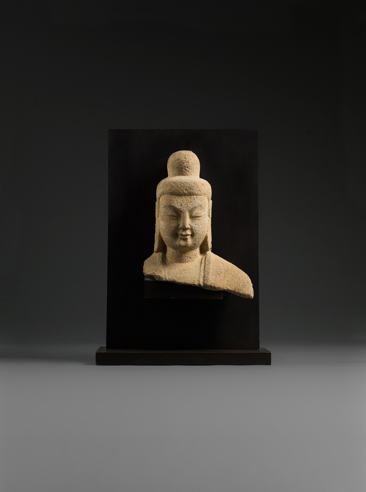 Sandstone head and shoulders of Buddha