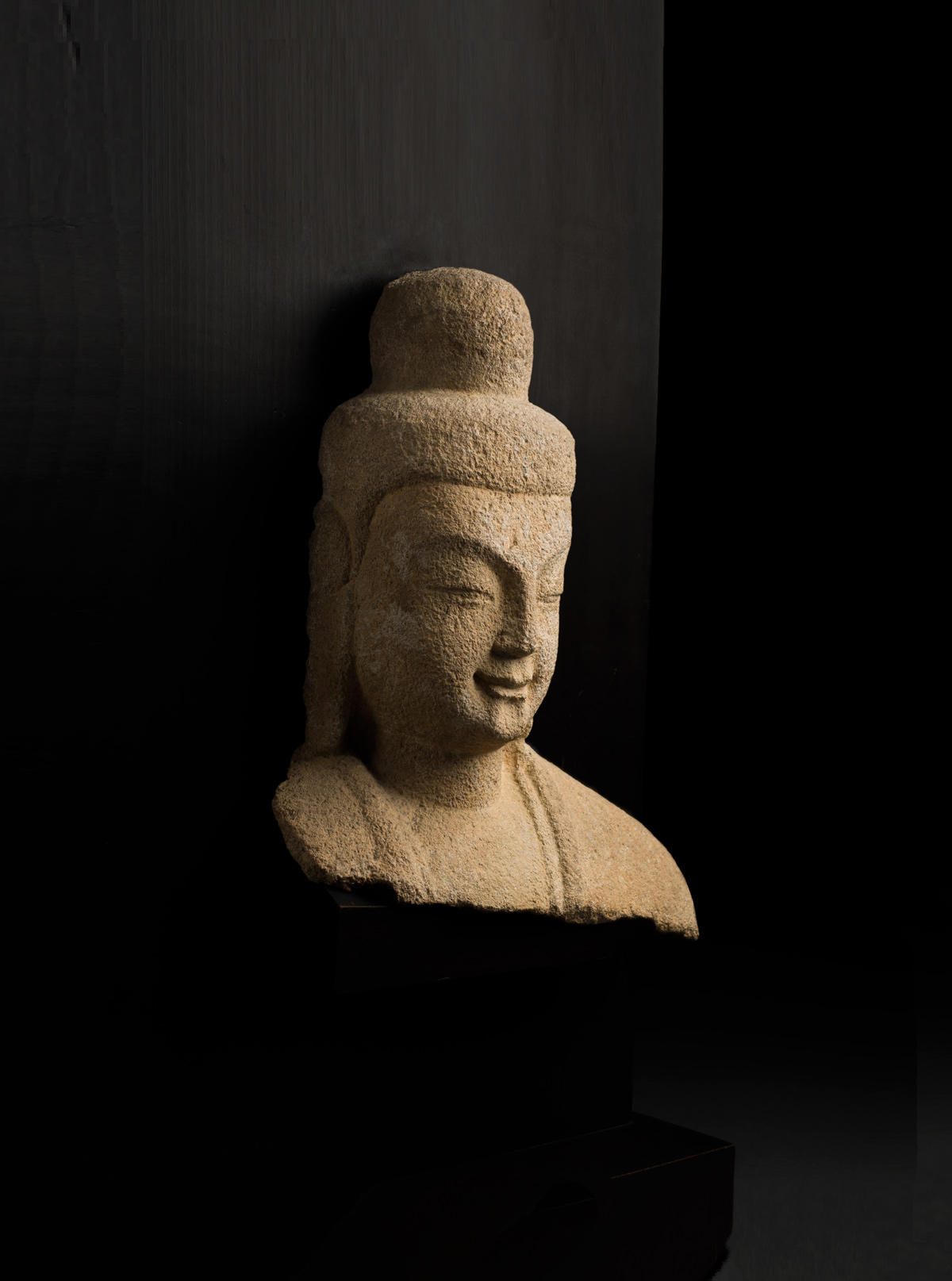 Sandstone head and shoulders of Buddha